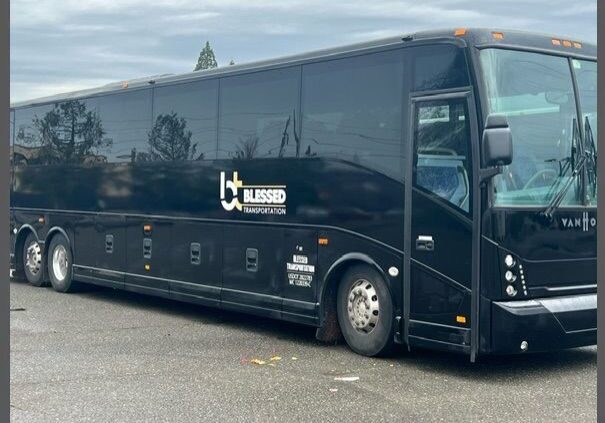 A black bus parked in the parking lot.