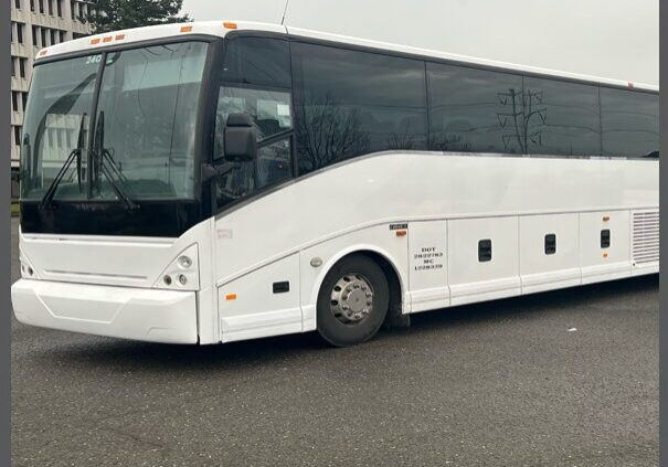 A white bus is parked in the parking lot.