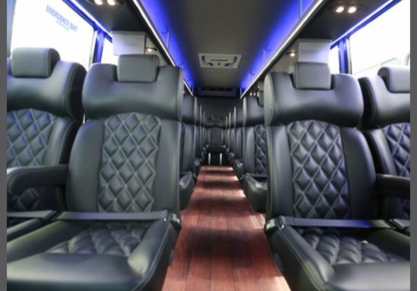 A bus with black seats and blue lights on the side.